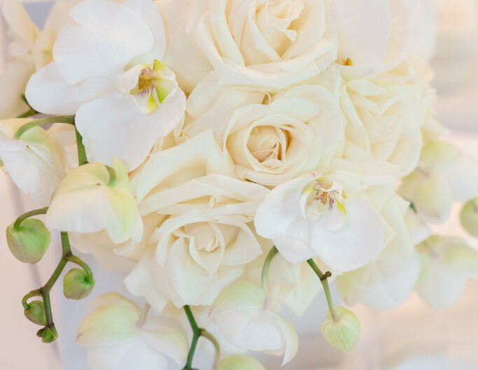 A delicate wedding bouquet of ivory roses and orchids