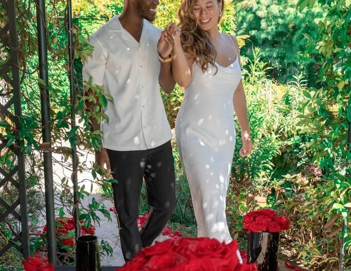 An overjoyed couple celebrates their engagement in a lush garden at Lake Como, with a table set for romanc